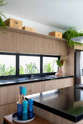 Cozinha com bancadas pretas e armários em madeira
