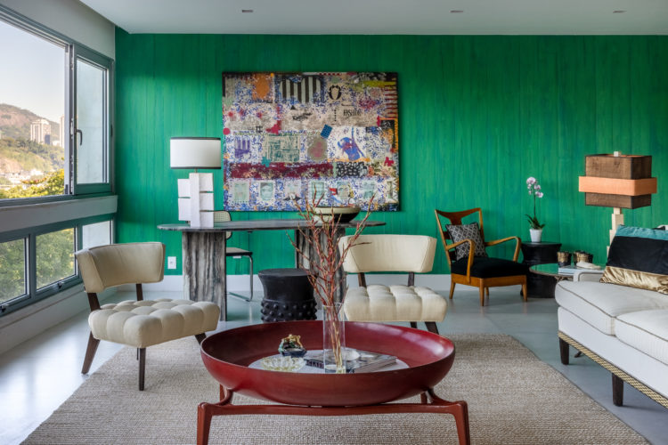 Estilo francês com alma carioca. Apartamento com parede verde e uma obra obra de arte. 