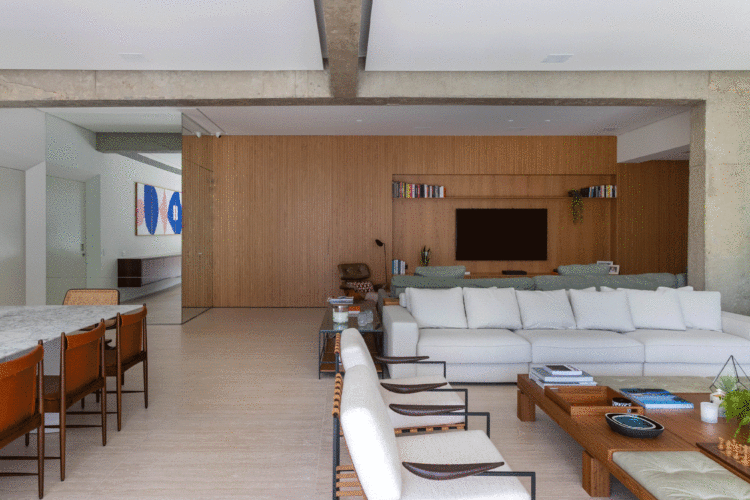 Sala com a parede de fundo revestida em madeira e uma tv 