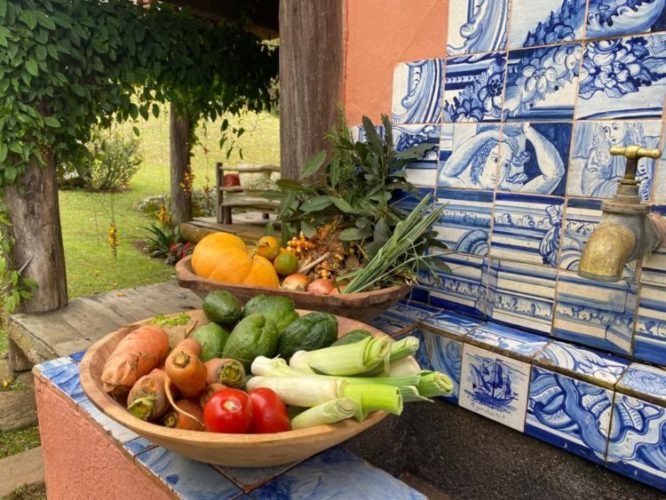 Pia do lado de fora da casa de campo, decorada com azulejos portugueses e legumes colhidos na horta.