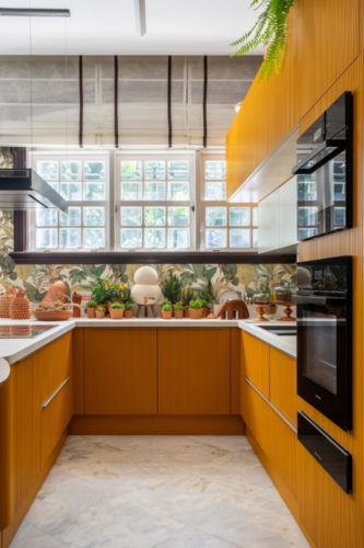 Cozinha na mostra CasaCor Rio 2023. Papel de parede estampado e armários amarelos em U