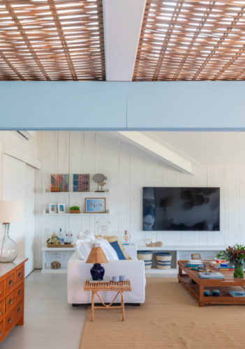 Sala em uma casa em Búzios decorada em tons claros, branco e azul