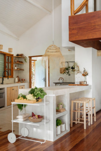 Casa de campo com estética rustica em harmonia com a natureza ao redor. Cozinha com teto pintado de branco