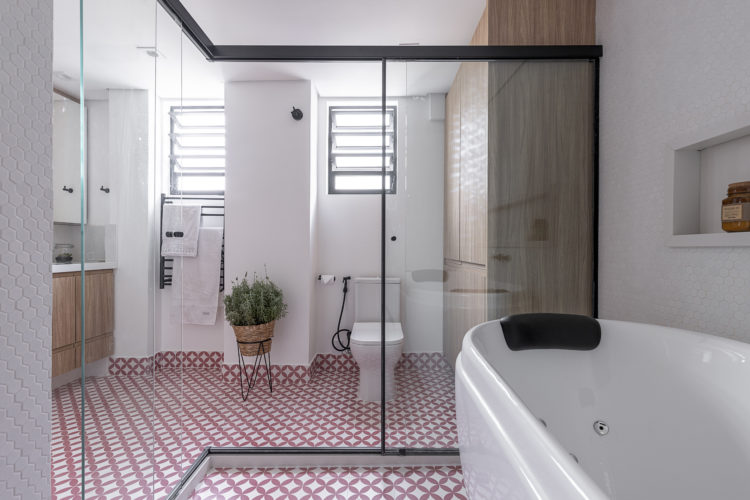 Um banheiro de casal com o piso em azulejo hidráulico estampada de losangos vermelhos