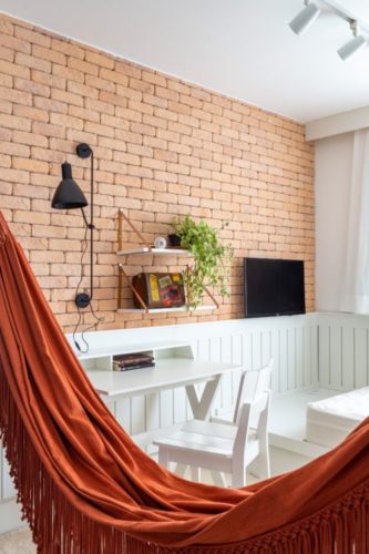Reforma de apartamento no Brooklin, São Paulo, proporciona uma casa com "cara de vida de verdade", para um casal com dois filhos, um de nove e outro de doze anos.  Com uma rotina de trabalho híbrida, possuem mais de um ambiente para home office em casa. Meia parede em tijolinho e lambri branco, para o home office
