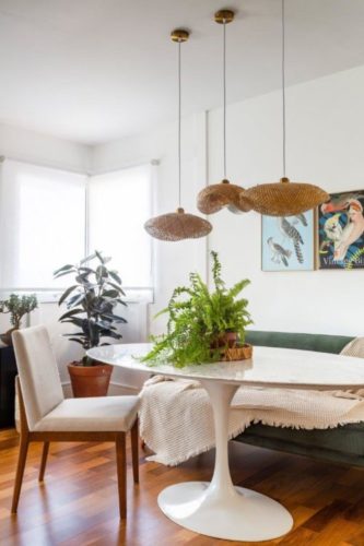 Reforma de apartamento no Brooklin, São Paulo, proporciona uma casa com "cara de vida de verdade", para um casal com dois filhos, um de nove e outro de doze anos.  Com uma rotina de trabalho híbrida, possuem mais de um ambiente para home office em casa. Pendentes em palha em cima da mesa de jantar
