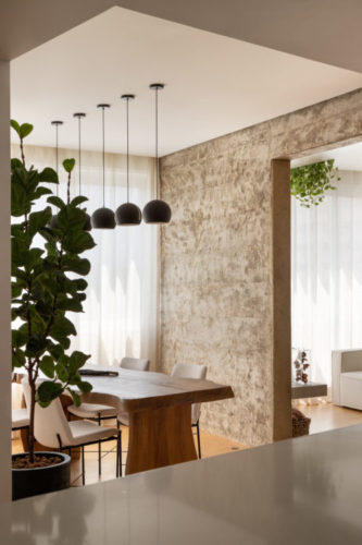 Vigas de concreto, reboco aparente e parede com textura artesanal dão o tom nesse apartamento de 130m2 em Ipanema.