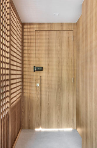 Hall de entrada com porta mimetizada em madeira