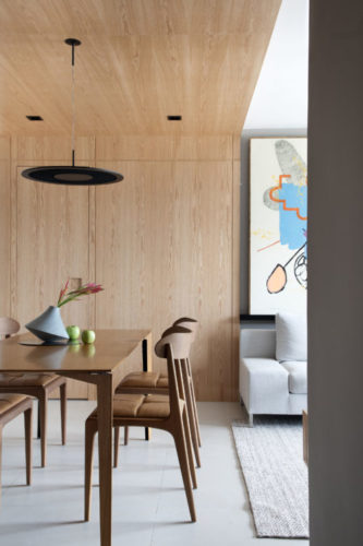 Mix de materiais marca o décor deste apartamento de 110m2, em Niterói. Para setorizar o espaço da mesa de jantar, a arquiteta revestiu as paredes e o teto em madeira, inclusive as portas, criando um efeito mimetizado.