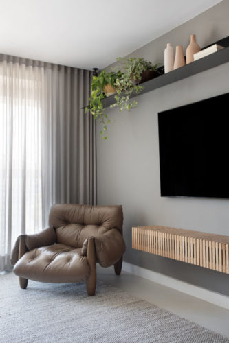 Mix de materiais marca o décor deste apartamento de 110m2, em Niterói. Cadeira Mole de Sergio Rodrigues ao lado da TV