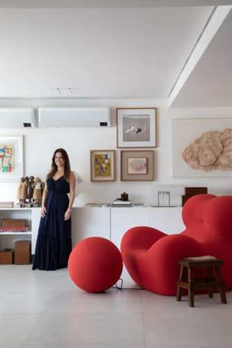 A arquiteta Ana Moura na sala de seu apartamento, ao lado da poltrona Up.