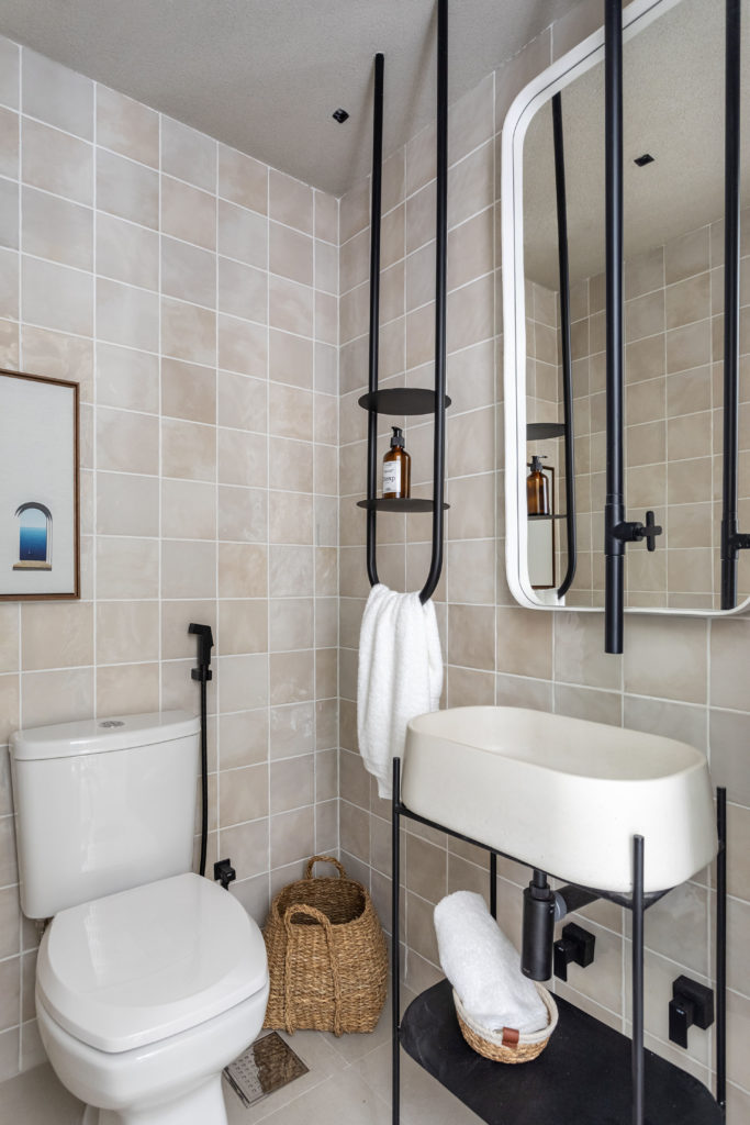 Banheiro com tornerira e o pendurador de toalha, feitos em aço tubular preto