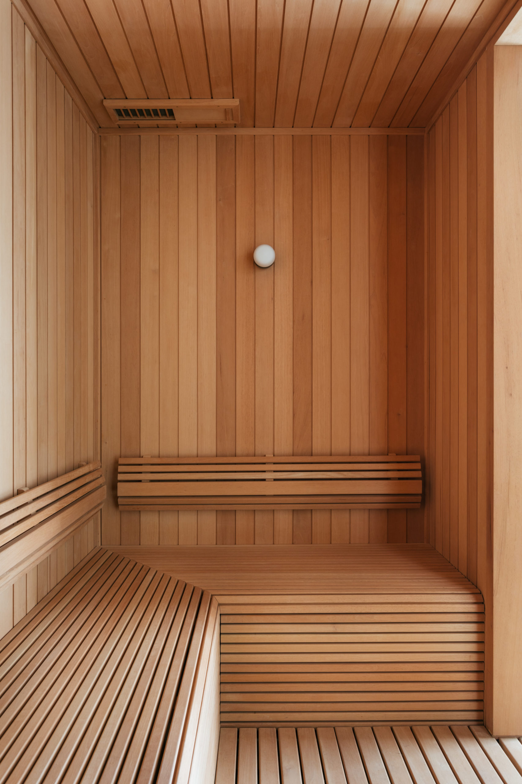 Sauna toda revestida em madeira, no centro de um apartamento.
