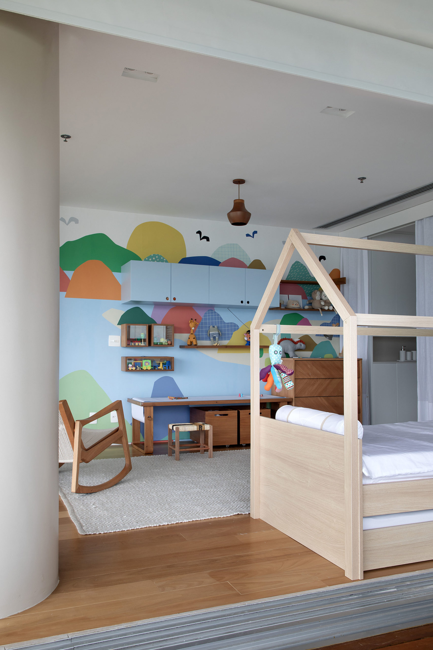 Quarto de criança decorado com pinturas coloridas na parede da bancada e cama montessoriana