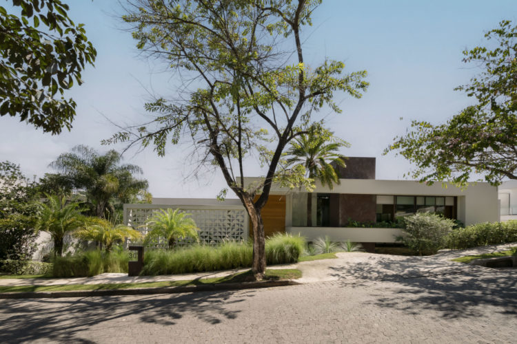 Jardim tropical e integrado à arquitetura em casa mineira