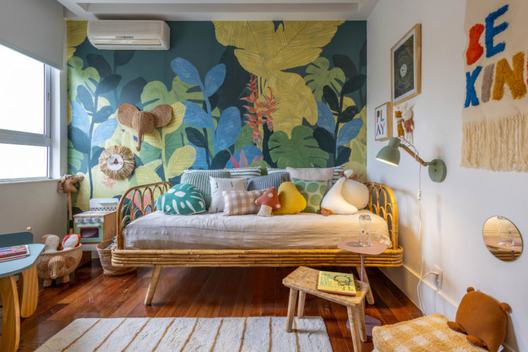 Quarto de criança, super colorido. Papel de folhagens nas cores verdes, azul e amarelo. Como cama de vime,