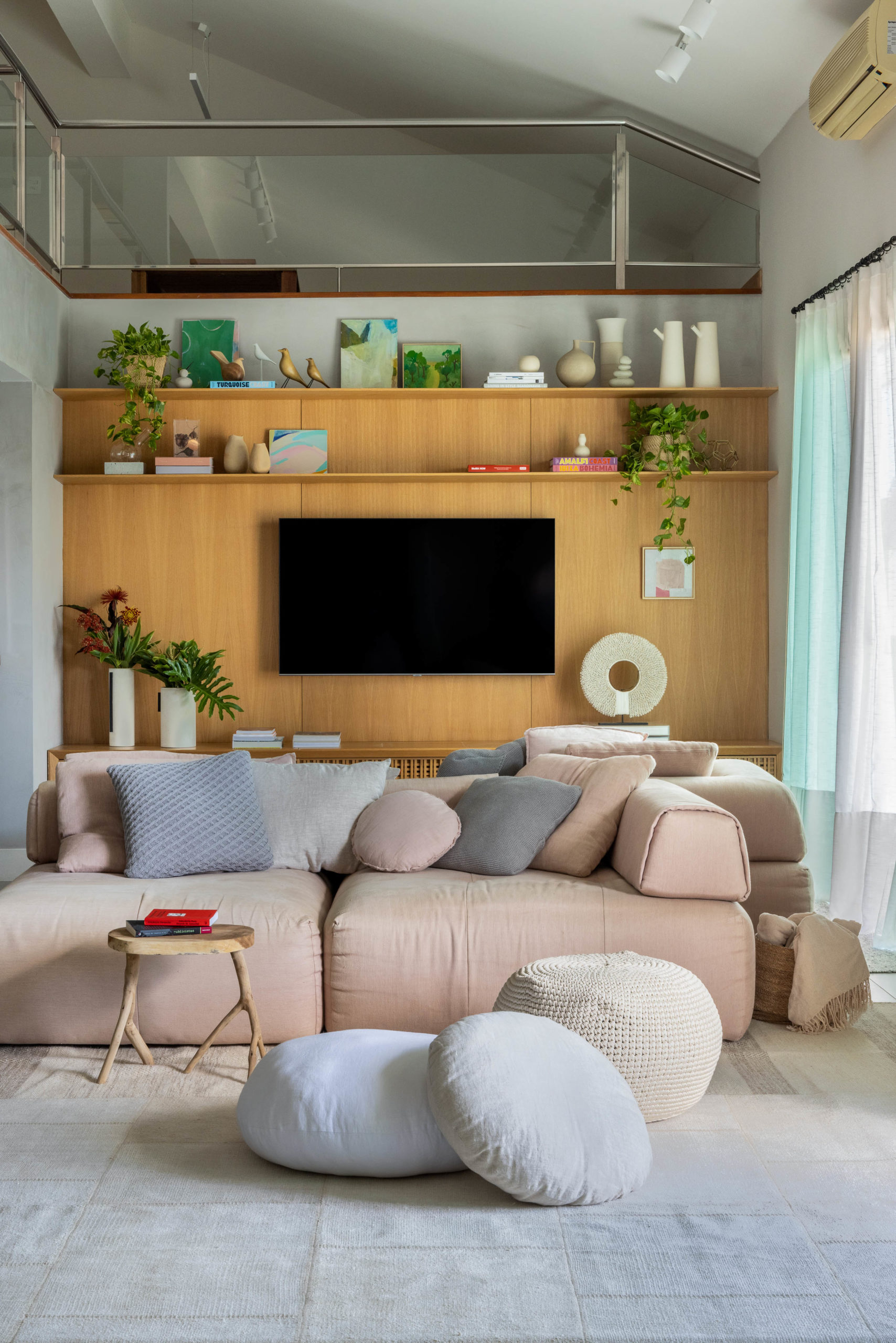 Sala com ambientes integrados, sofá que atende aos dois lados do living e marcenaria na parede da TV