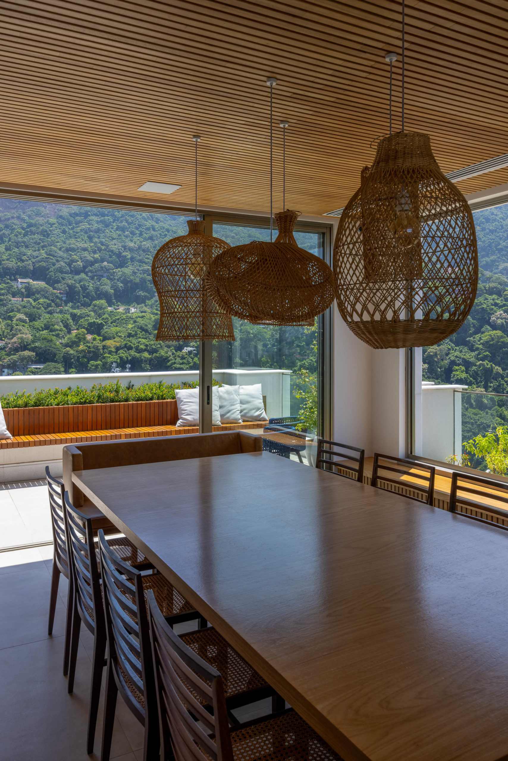 Família troca apartamento por cobertura no mesmo prédio, mas reproduz planta e décor do antigo em reforma tocada por Mauricio Nóbrega. Sala de jantar no segundo andar da cobertura, com vista para a praia e a Pedra da Gávea, no Rio de Janeiro.