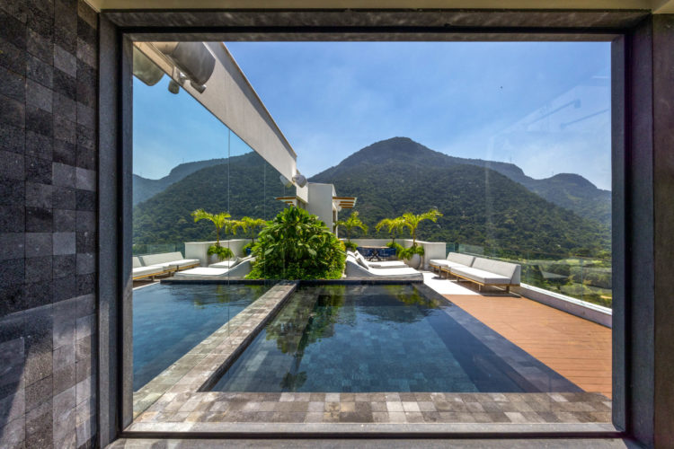 Família troca apartamento por cobertura no mesmo prédio, mas reproduz planta e décor do antigo em reforma tocada por Mauricio Nóbrega. Janela da sauna, no segundo andar da cobertura, tem vista para a Pedra da Gávea, no Rio de Janeiro.