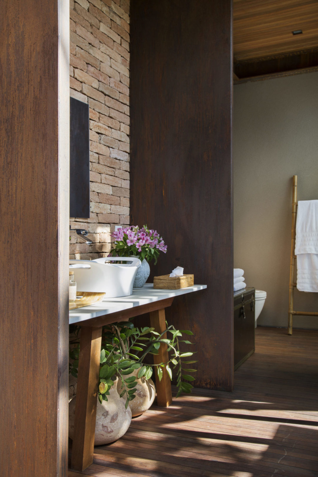 Lavabo da área externa, com parede de tijolinho e pilar em aço corten