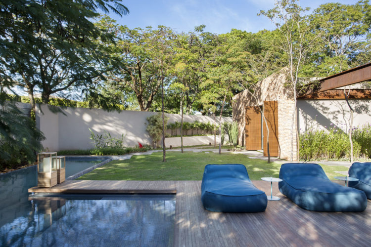 Área externa de uma casa em São José sp. Piscina, deck em madeira e espreguiçadeiras na cor azul