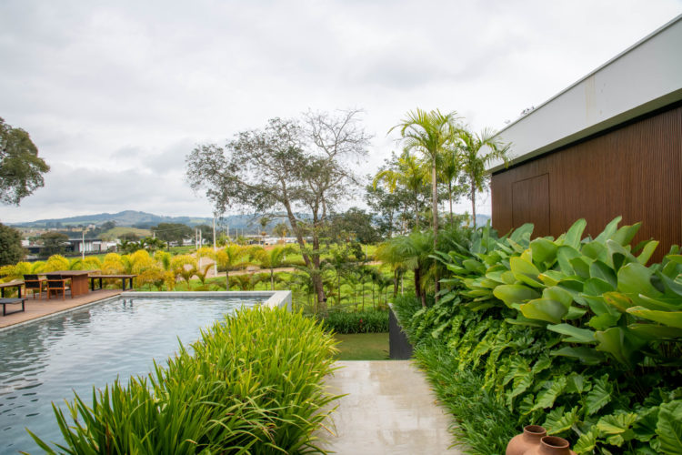 Casa de campo em Bom Sucesso (MG) com uma generosa área verde de 790 m², com paisagismo exuberante e tropical assinado pela paisagista Flávia D'Urso. No total, foram plantadas no total 33 espécies de plantas variadas.