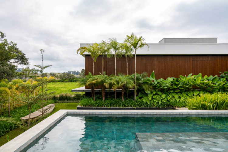 Casa de campo em Bom Sucesso (MG) com uma generosa área verde de 790 m², com paisagismo exuberante e tropical assinado pela paisagista Flávia D'Urso. No total, foram plantadas no total 33 espécies de plantas variadas.