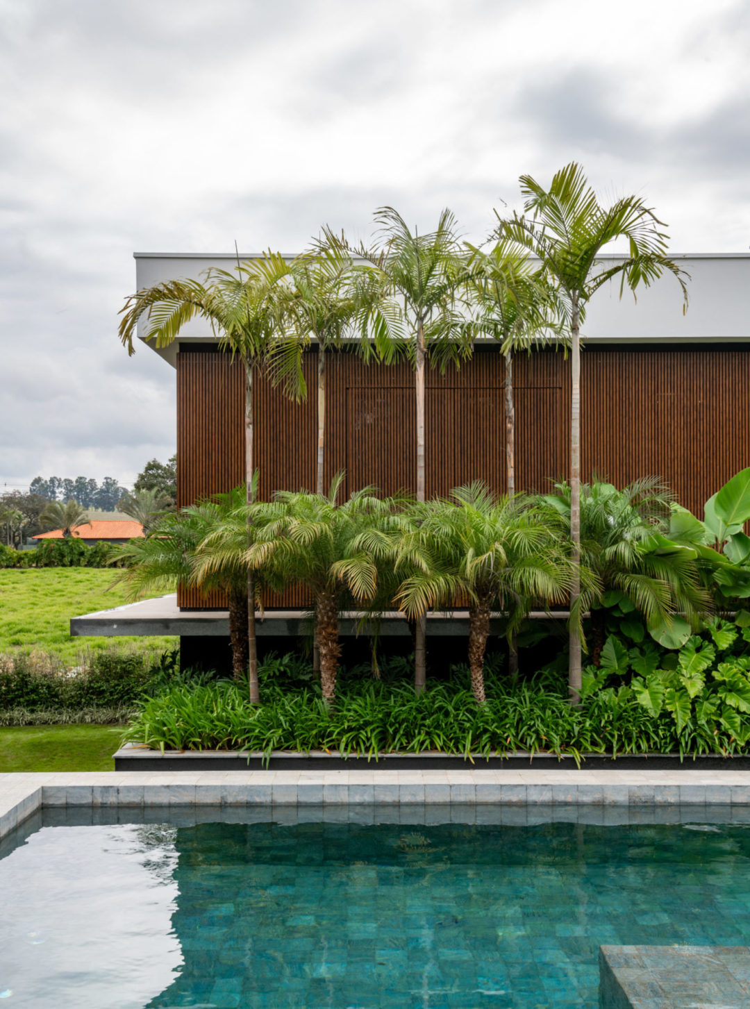 Casa de campo em Bom Sucesso (MG) com uma generosa área verde de 790 m², com paisagismo exuberante e tropical assinado pela paisagista Flávia D'Urso. No total, foram plantadas no total 33 espécies de plantas variadas.