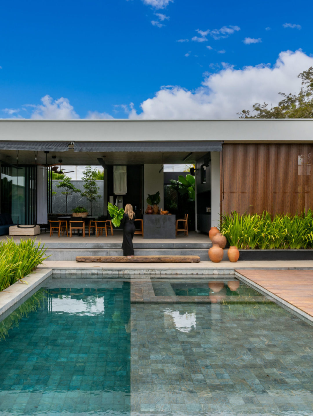 Casa plana com paisagismo emoldurando a parte da piscina