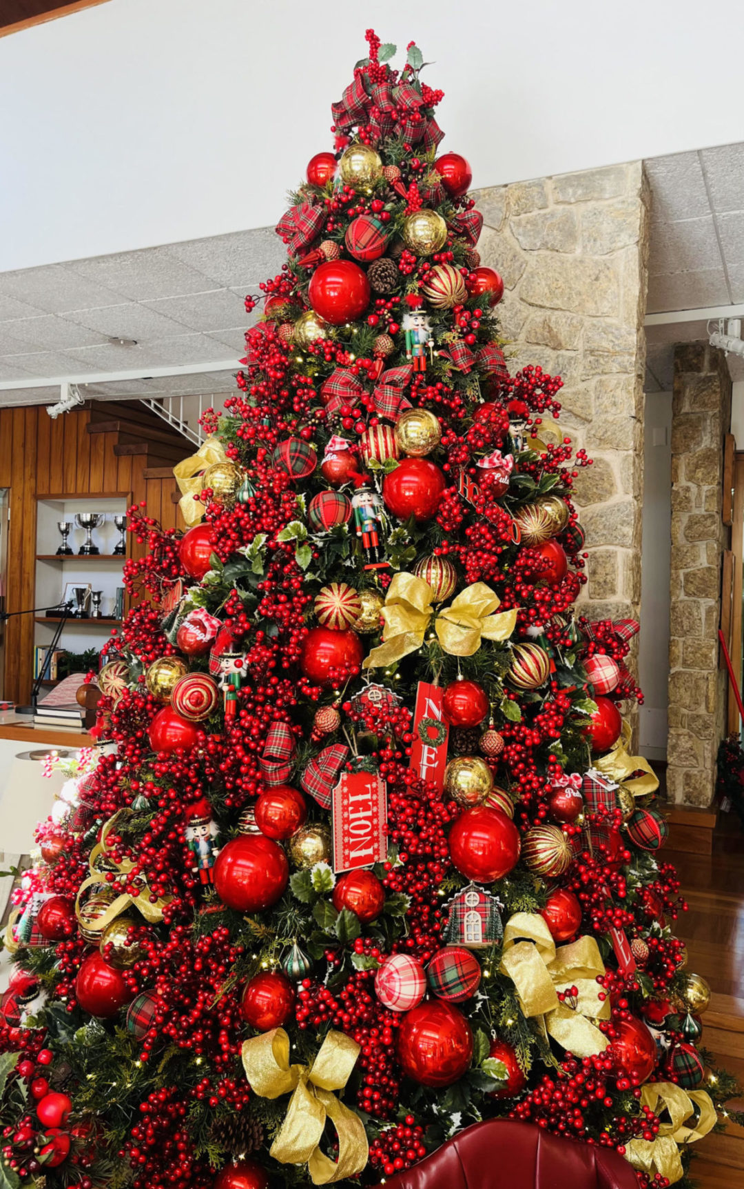 As luzes estão piscando, o panetone aparece em várias versões e a uva-passa pede passagem. Arvore de Natal com bolas vermelhas e laços dourados