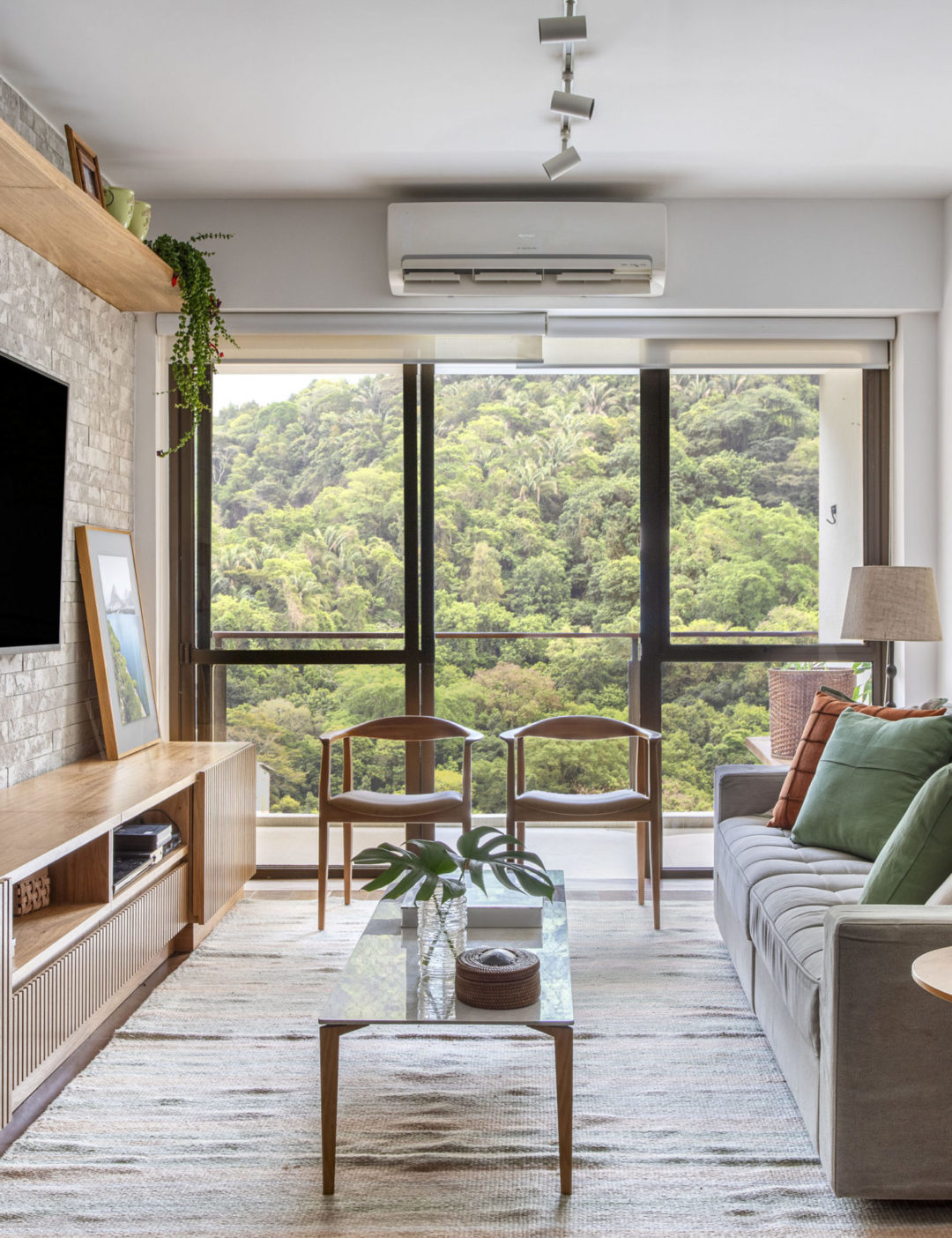 Sala com vista para a mata neste apartamento de (110m2) contemporâneo, aconchegante e alegre localizado na Gávea (Rio de Janeiro).