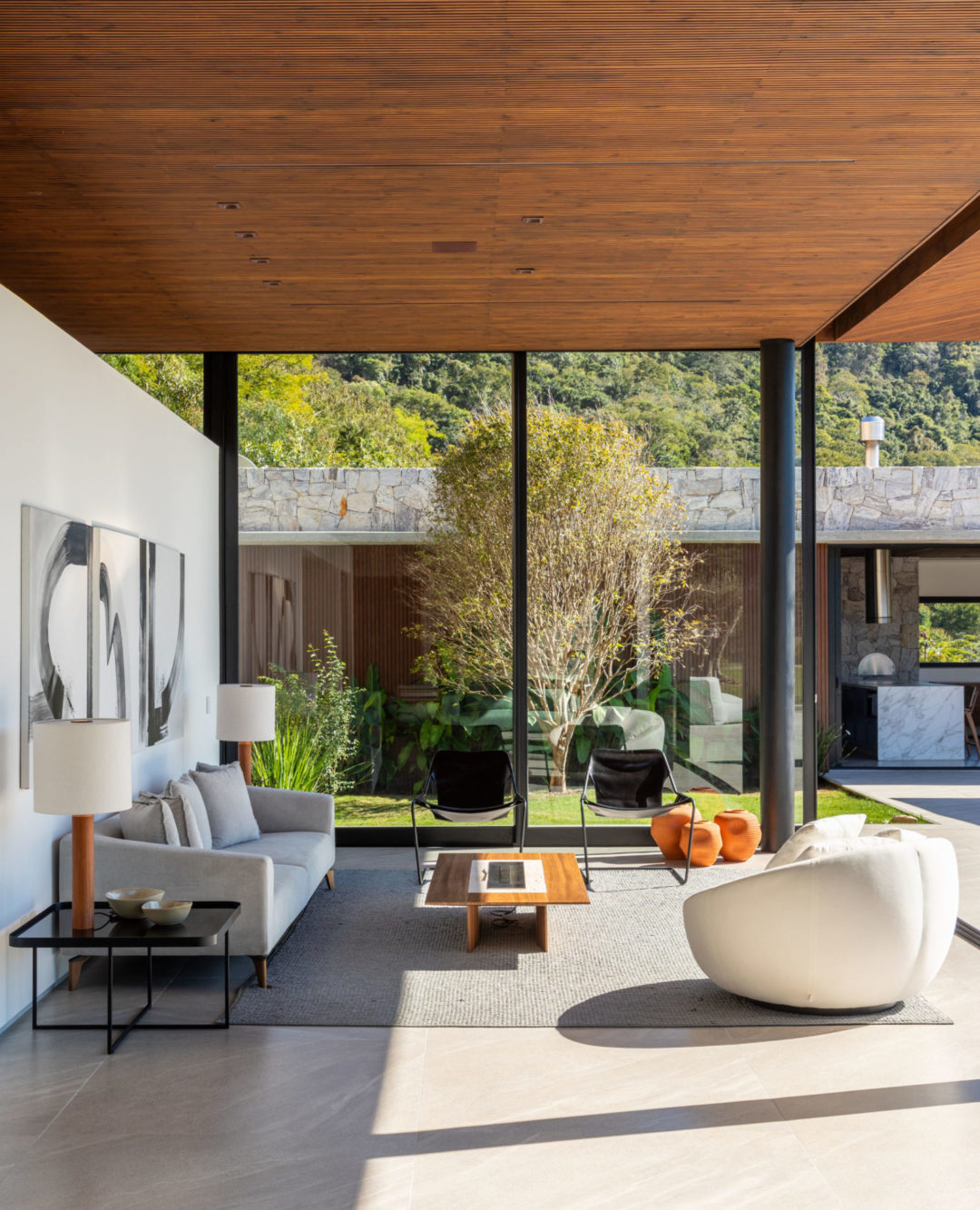 Localizada em Itaipava (distrito de Petrópolis, RJ), esta casa de campo é um refúgio moderno integrado à natureza. Na decoração, de estilo contemporâneo despojado, tudo é novo. Os arquitetos priorizaram móveis modernos e atuais assinados por designers brasileiros, com traços simples e atemporais, que ‘conversam’ com a arquitetura da casa, a exemplo das poltronas Paulistano, de Paulo Mendes da Rocha, as cadeiras de jantar Viky, do Bernardo Figueiredo, e as chaises Pitu, do Aristeu Pires.