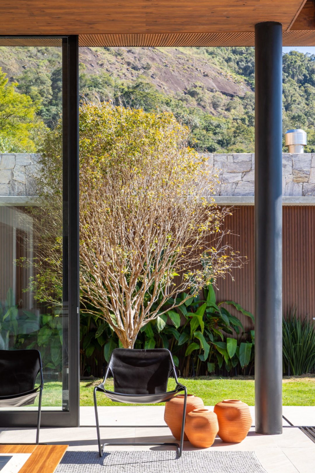 Localizada em Itaipava (distrito de Petrópolis, RJ), esta casa de campo é um refúgio moderno integrado à natureza. Na decoração, de estilo contemporâneo despojado, tudo é novo. Os arquitetos priorizaram móveis modernos e atuais assinados por designers brasileiros, com traços simples e atemporais, que ‘conversam’ com a arquitetura da casa, a exemplo das poltronas Paulistano, de Paulo Mendes da Rocha. 