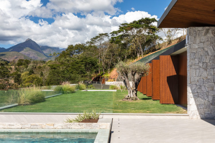 Localizada em Itaipava (distrito de Petrópolis, RJ), esta casa foi construída a partir de uma estrutura metálica aparente pintada de preto, com forro do teto em ripas de Pinus tonalizado e fachadas ora em esquadrias piso-teto de alumínio preto e vidro transparente (que permitem integrar os espaços internos com a área externa) ora em painéis articulados de alumínio ripado com pintura amadeirada, ora em pedra Moledo.