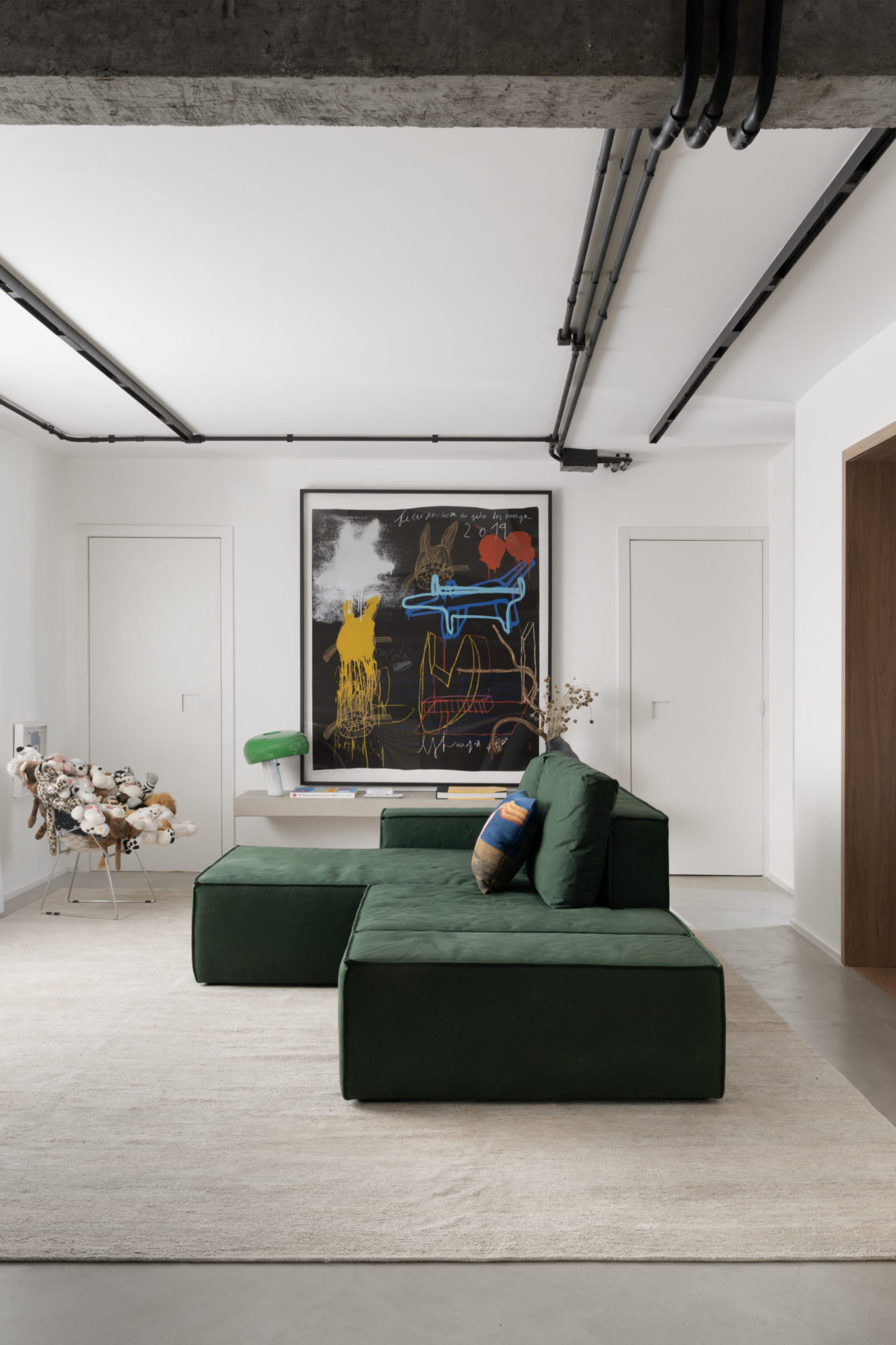 foto do sofá verde da sala de estar com um quadro ao fundo