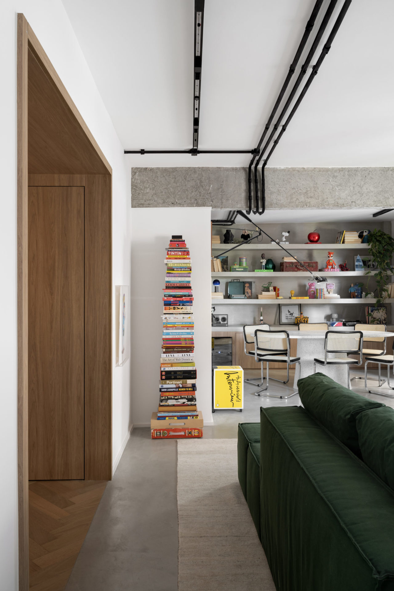 Visão da sala de estar e jantar com livros e estante