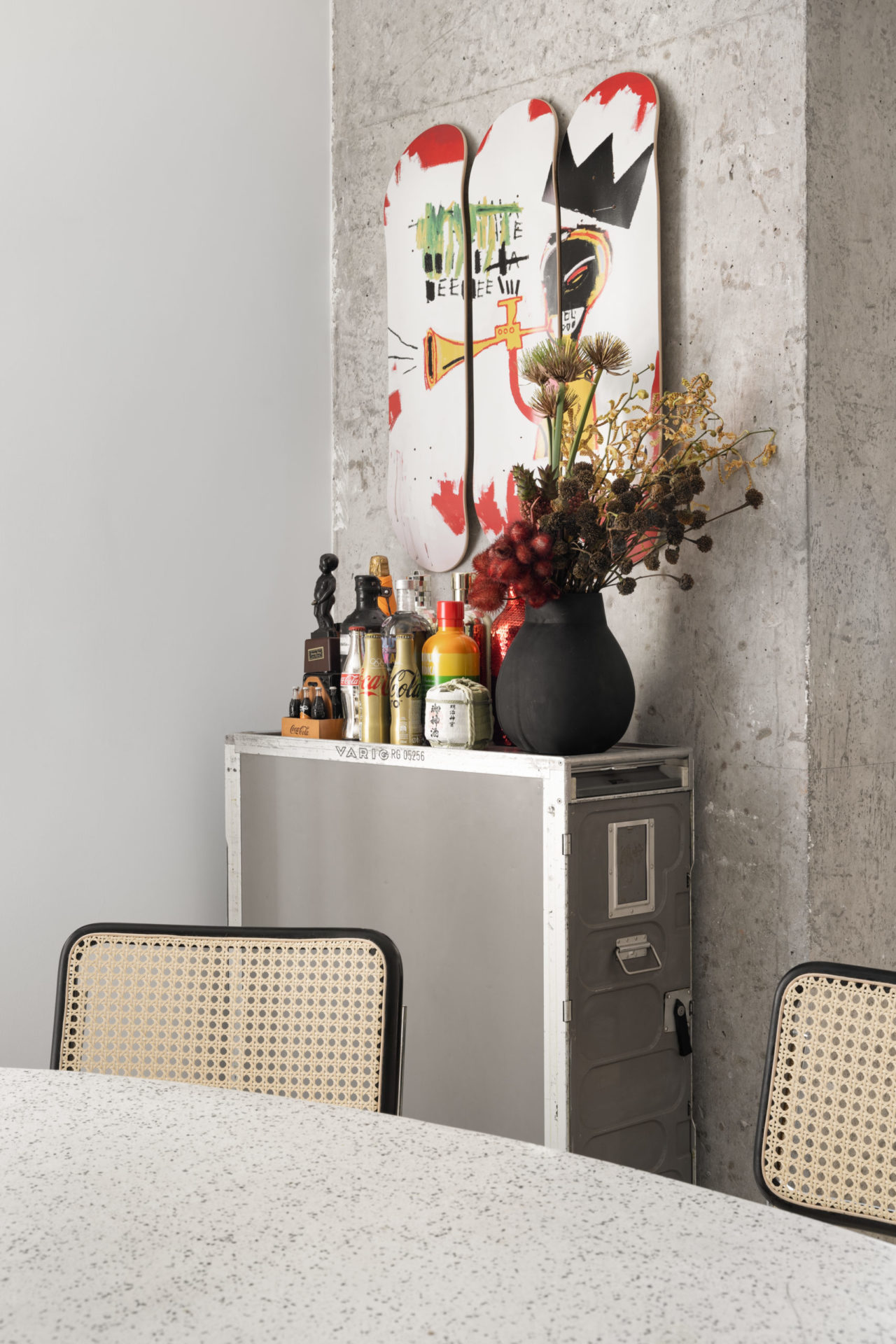 Cadeiras da mesa de jantar, vaso com flores e itens de colecionador