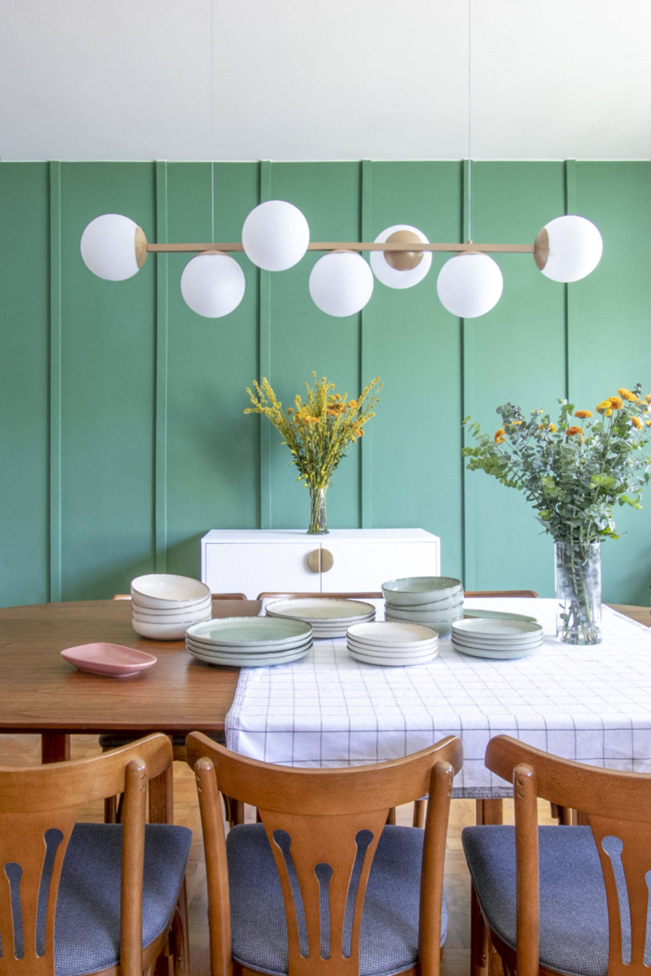 sala de jantar com parede verde e luminárias