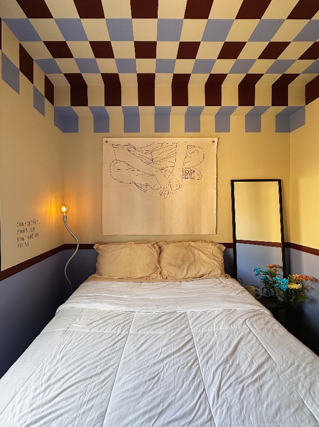 quarto com cama de casal e teto com pintura quadriculada