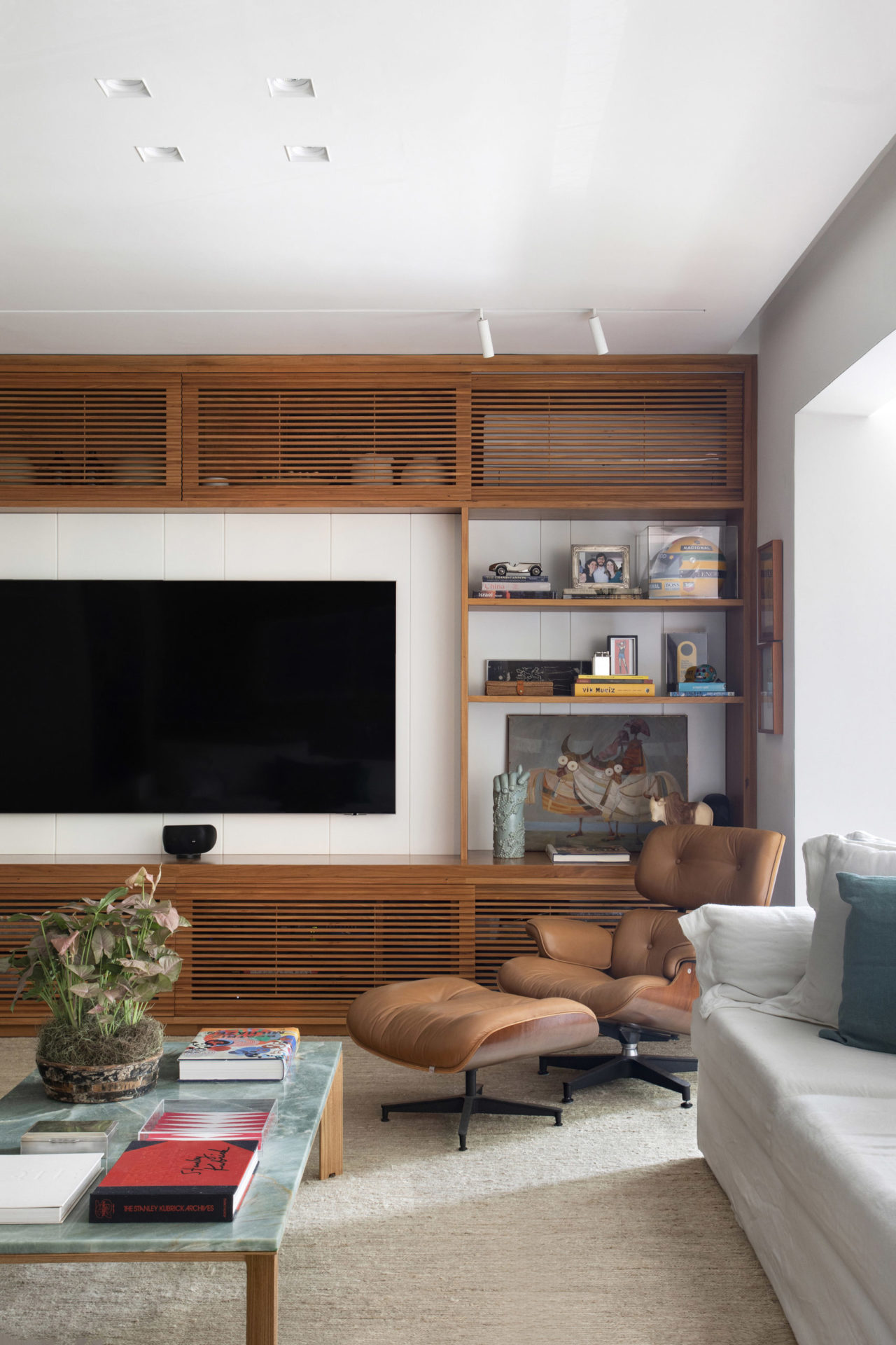 estante com tv e poltrona com banqueta