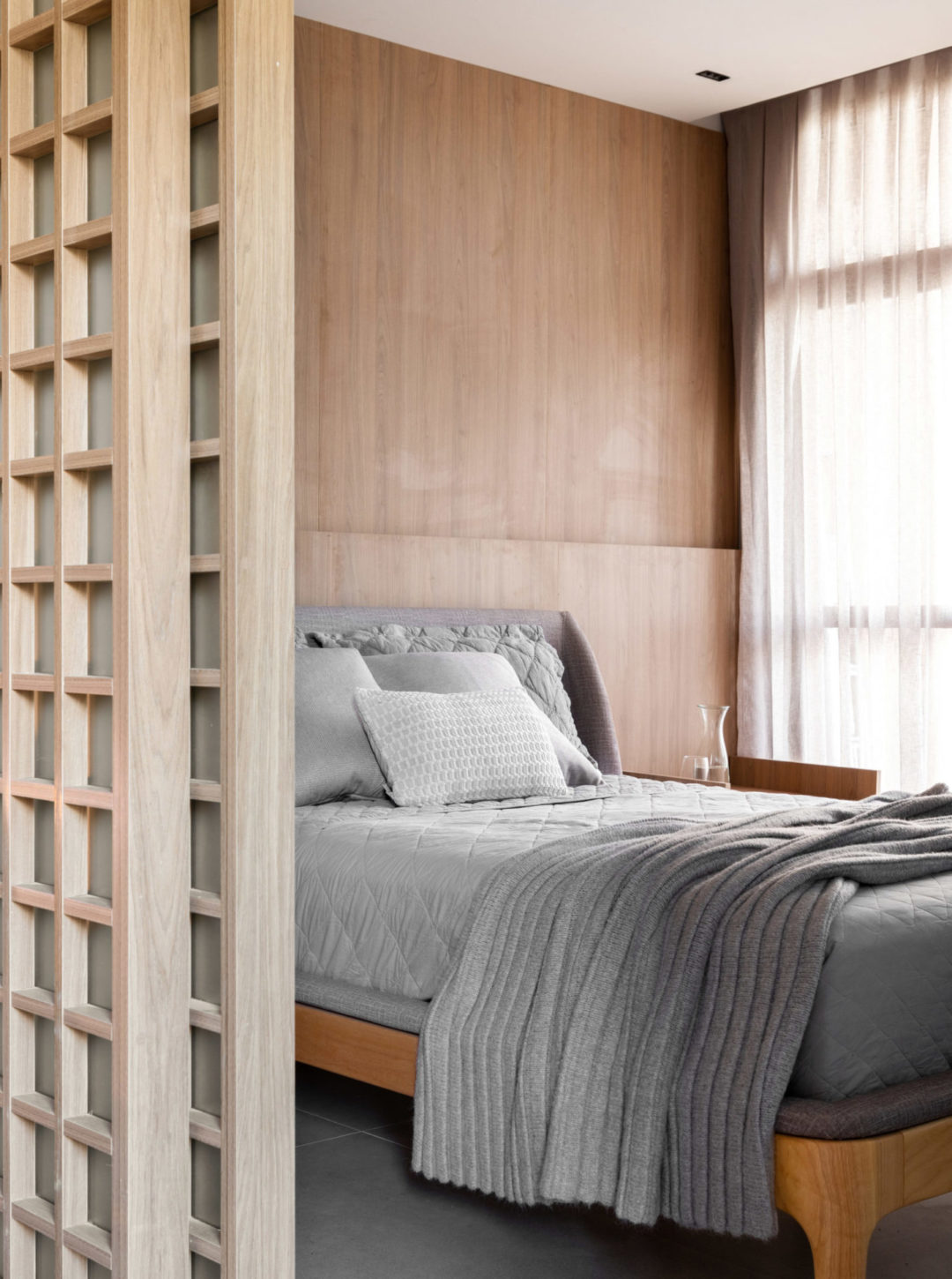 Quarto com a parede atrás da cama todo em madeira
