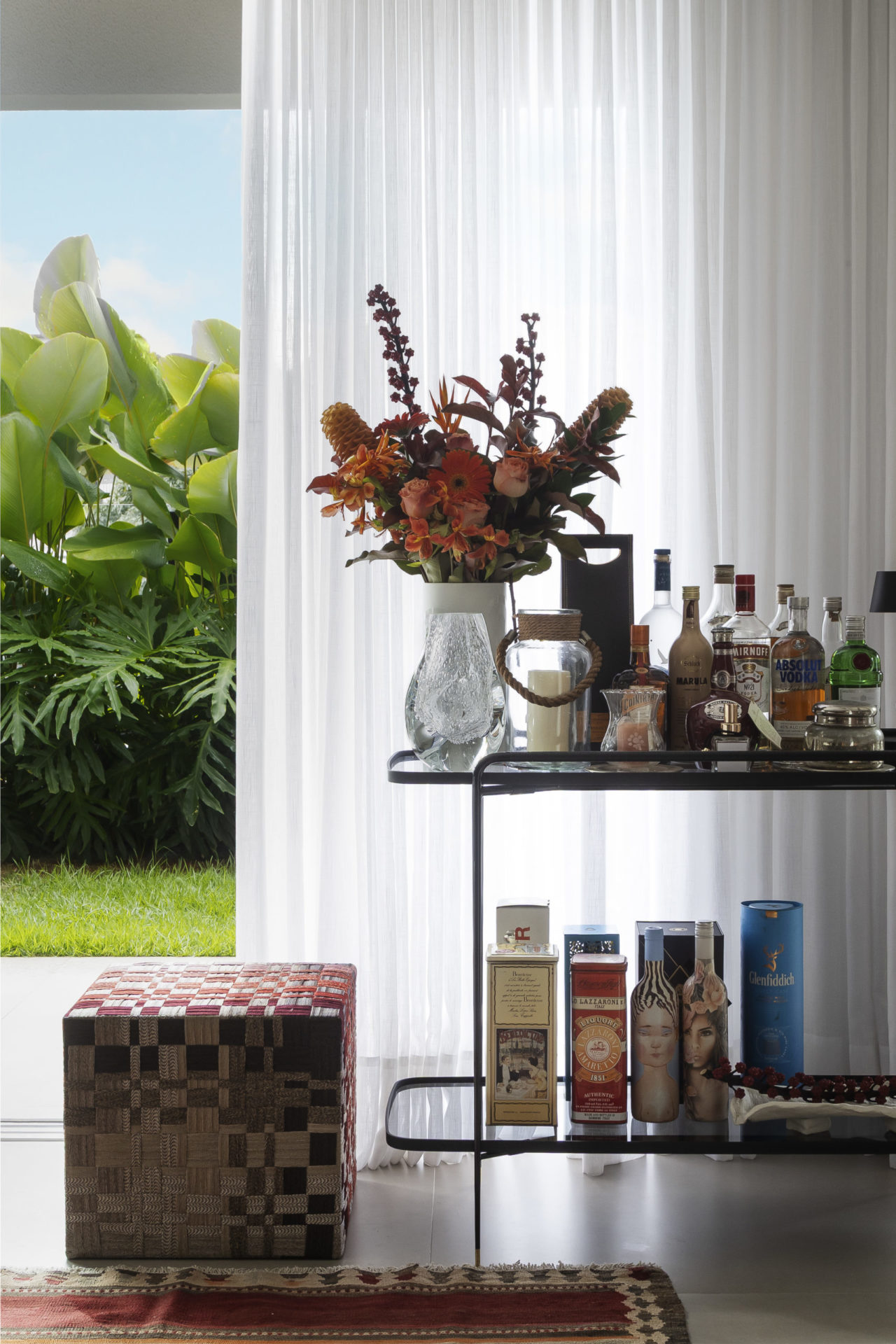 bar com bebidas e vaso de flores