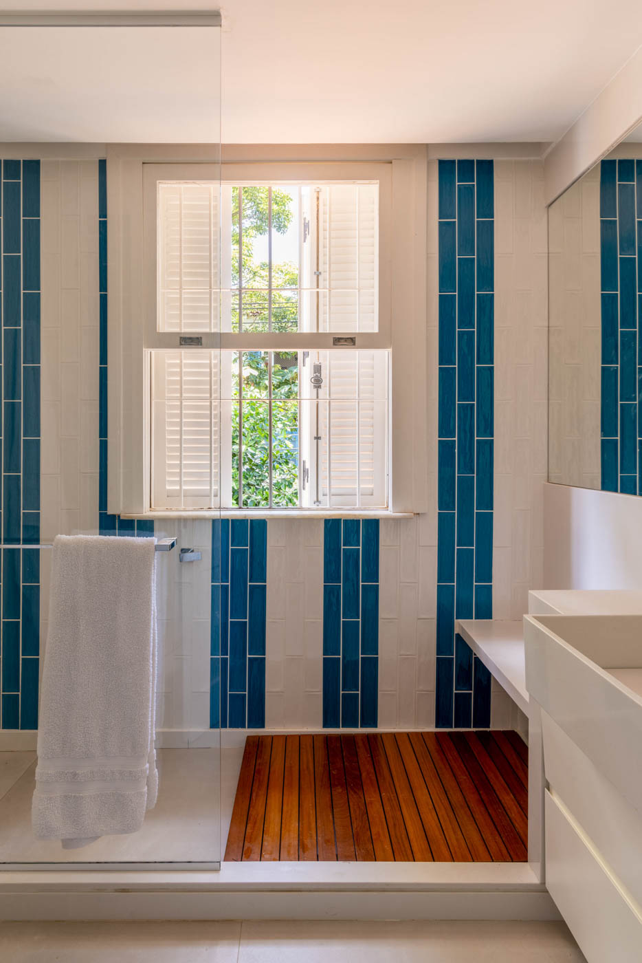 Banheiro com revestimento azul e branco, aplicado de forma que criam listras nestas cores