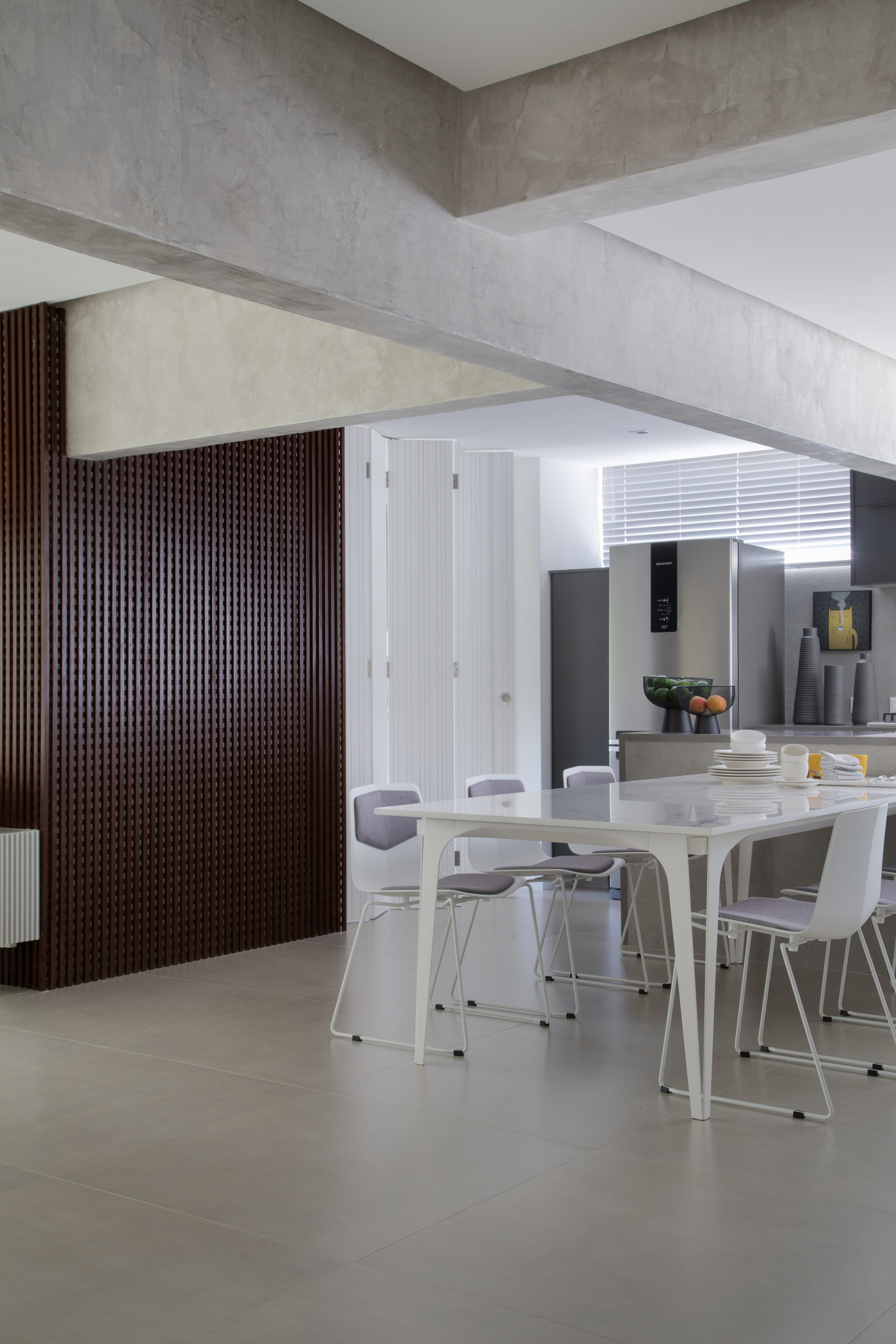 sala com mesa de jantar, cozinha ao fundo e vigas no teto