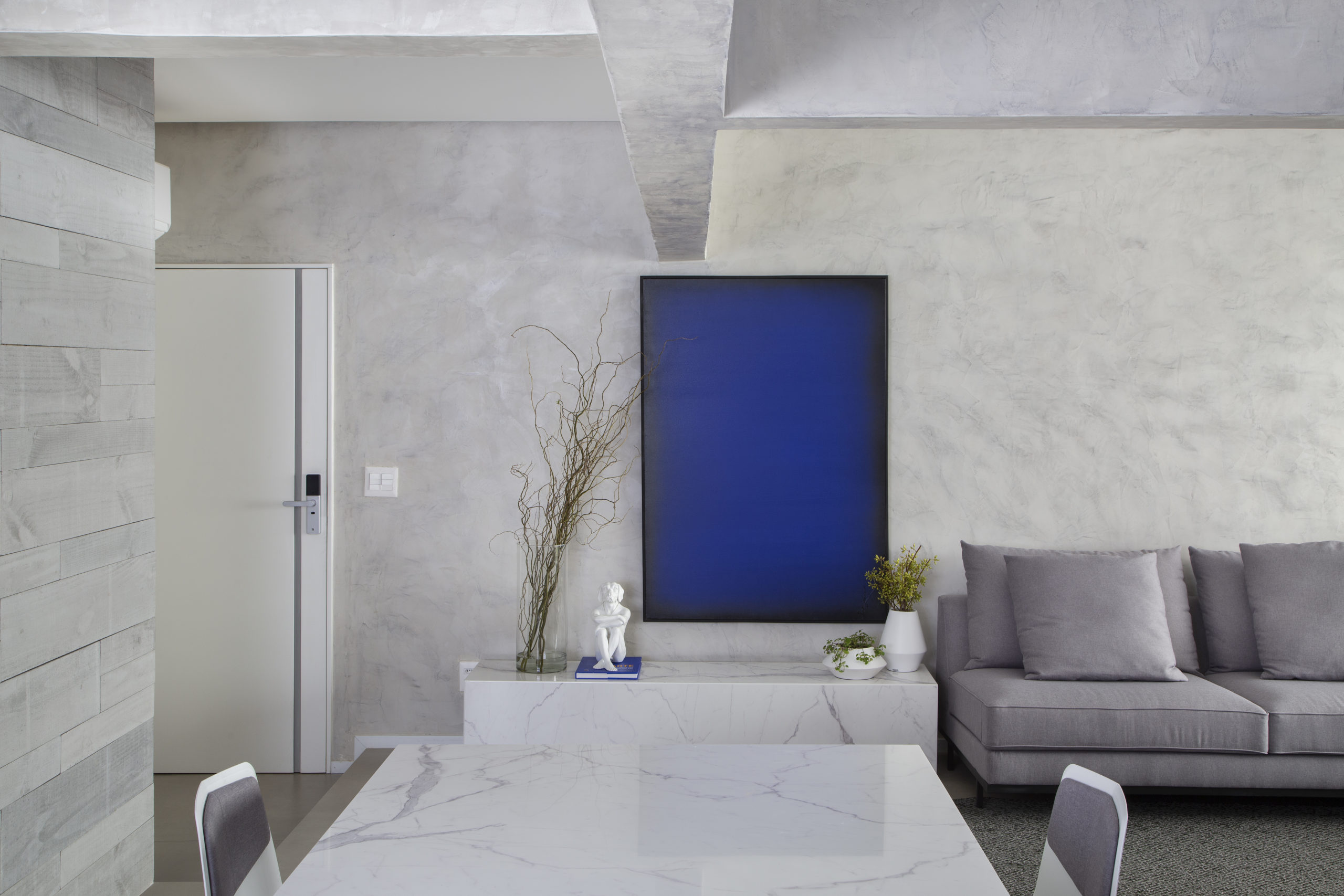 sala ampla, mesa de jantar branca, quadro azul e vigas no teto