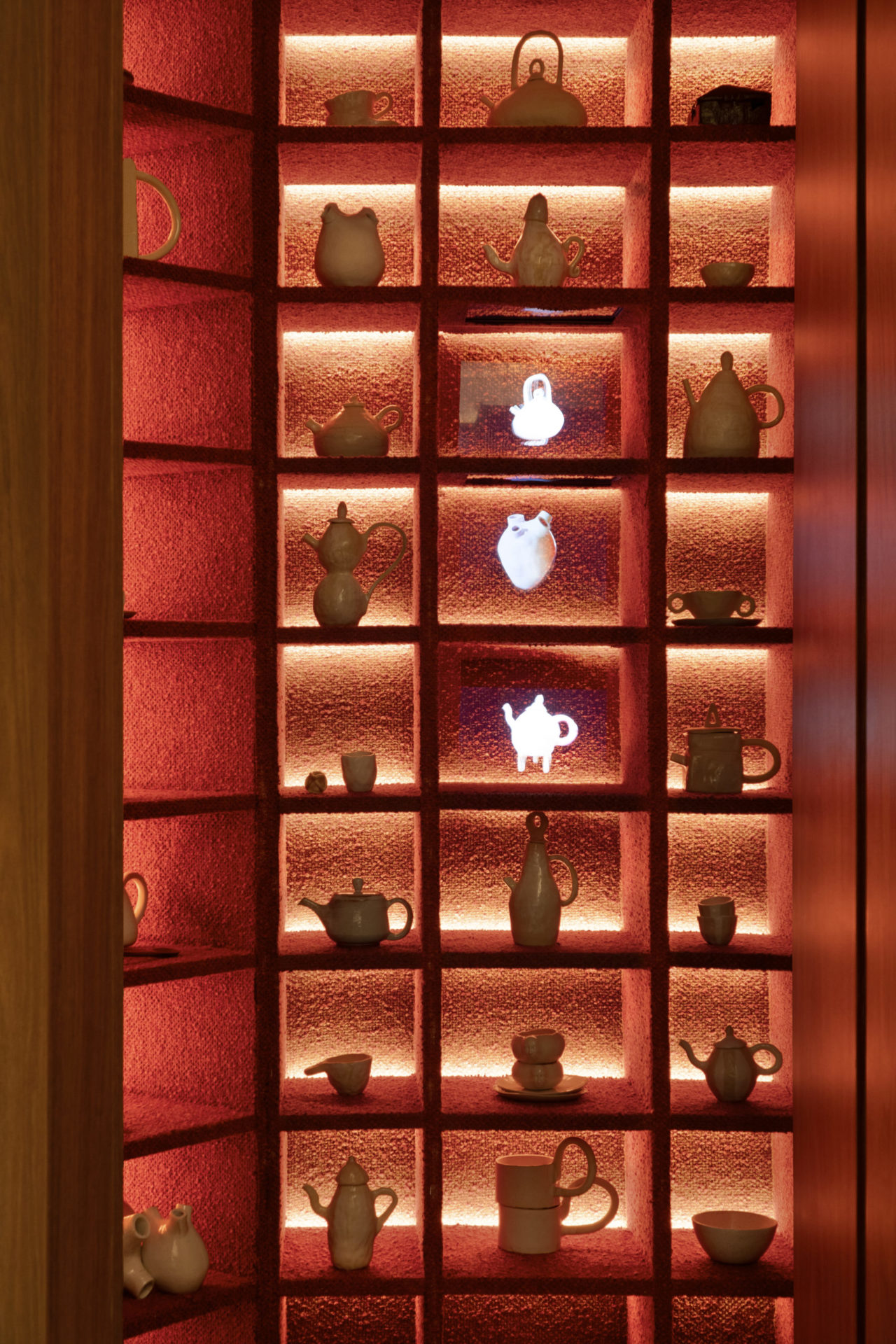 Espaço chamado no coração da casa com uma parede com nichos e objetos decorativos