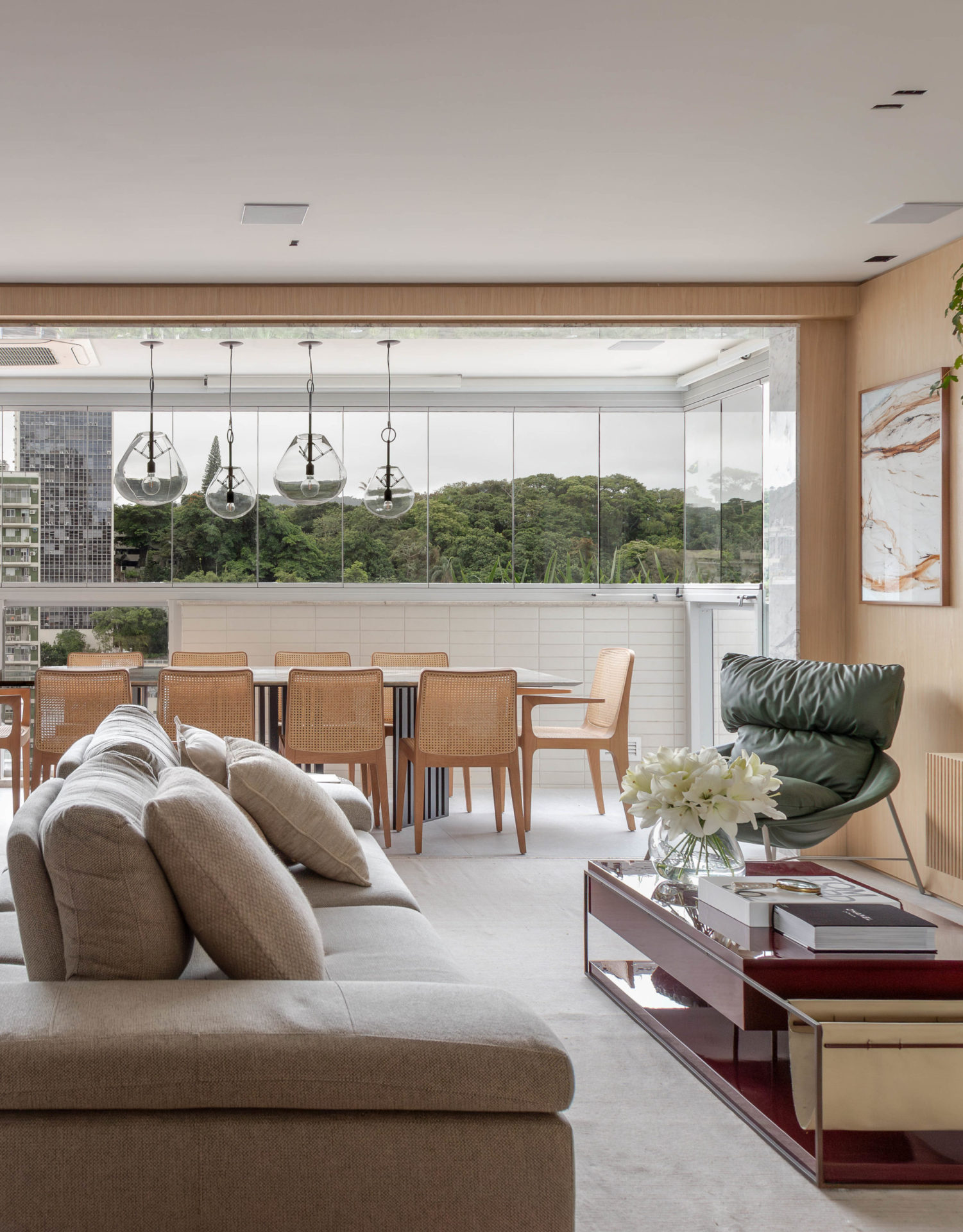 sala com poltrona Caati em verde e mesa de cento vinho