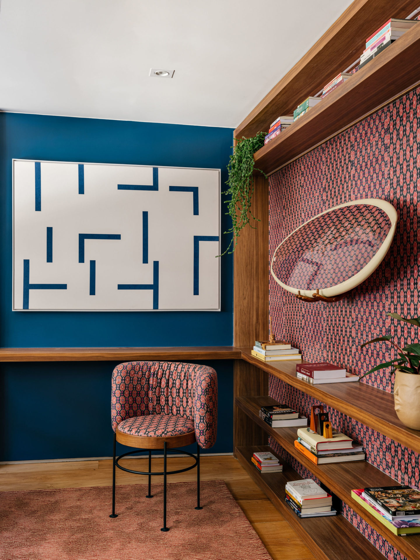 na foto ambiente com cadeira e parede com a mesma textura e outra parede azul com um quadro branco e azul