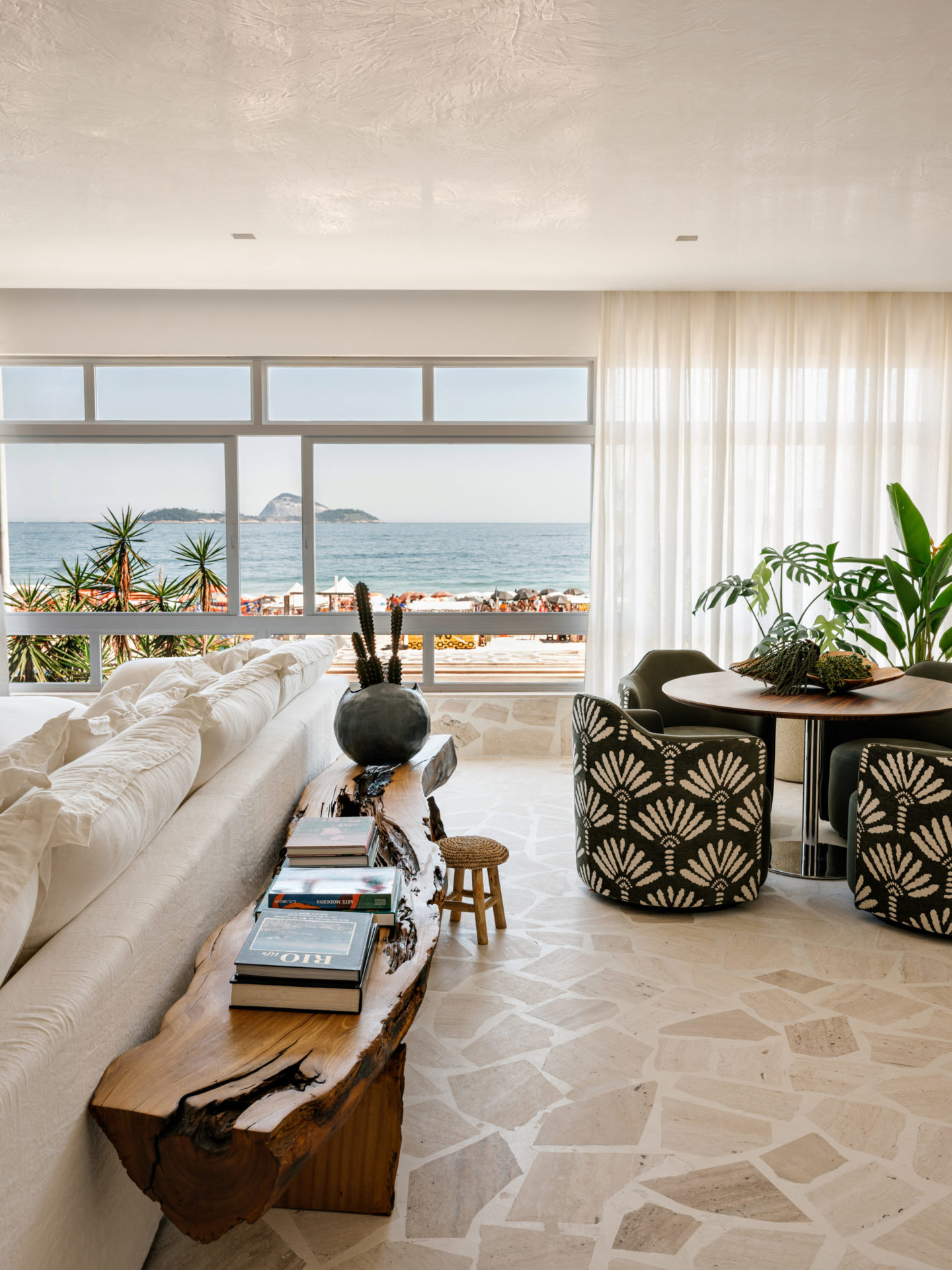 apartamento com vista para a praia do Leblon com mesa de almoço e banco aparador