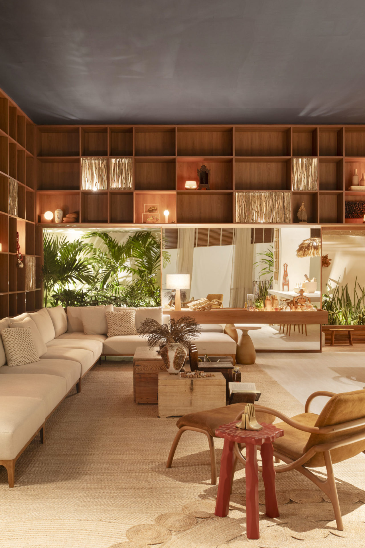sala de estar com sofá branco, poltrona e estante em L